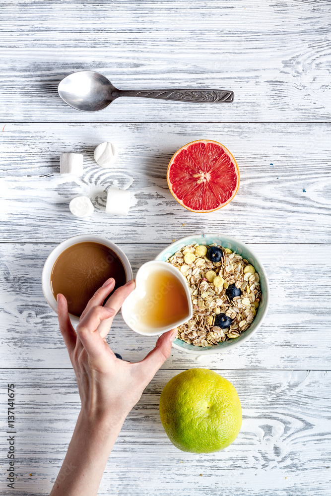 Breakfast concept with flowers on wooden background top view