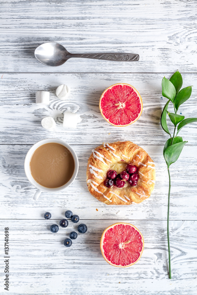 Breakfast concept with flowers on wooden background top view