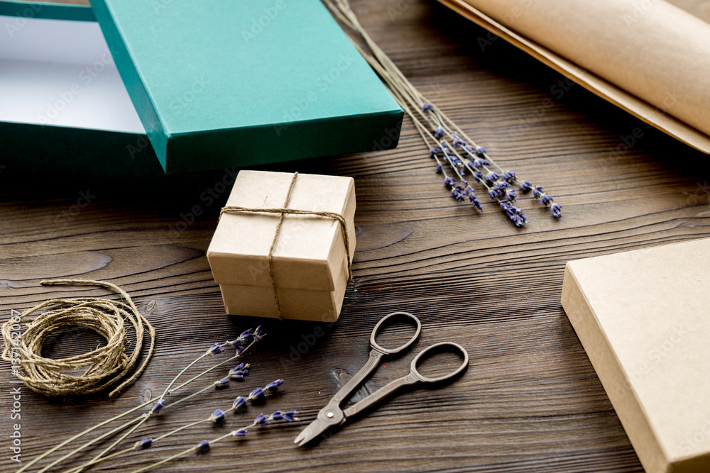 wrapping gifts in box for holiday on wooden background