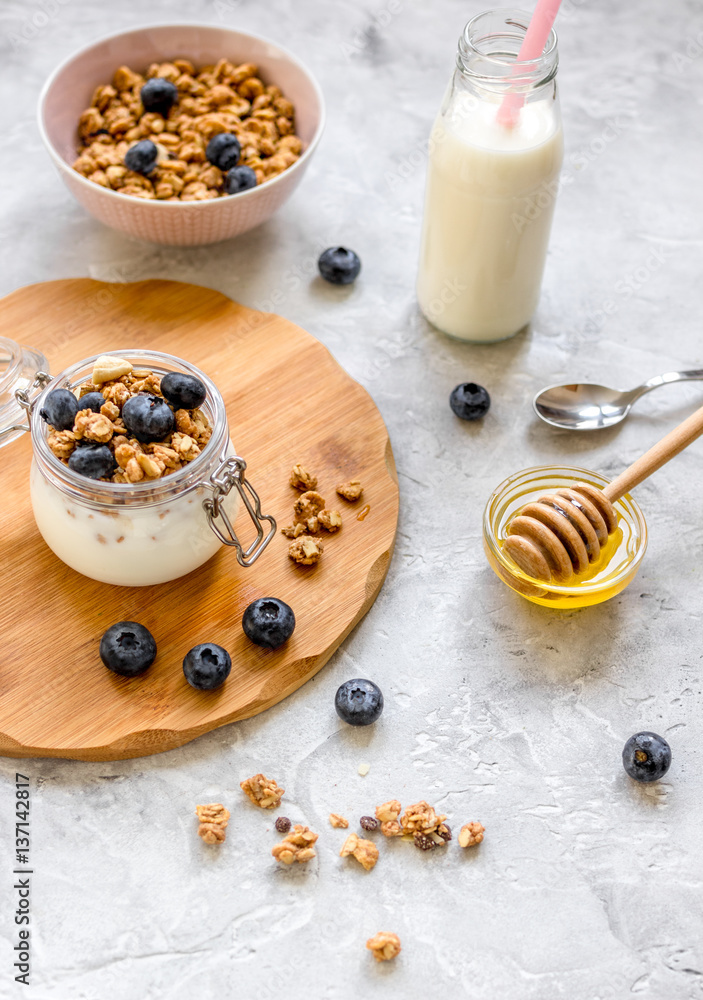 Morning granola with yogurt, honey and berries on white table