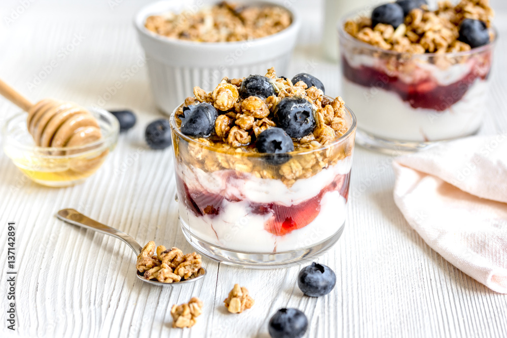 Morning granola with yogurt and berries on white kitchen background