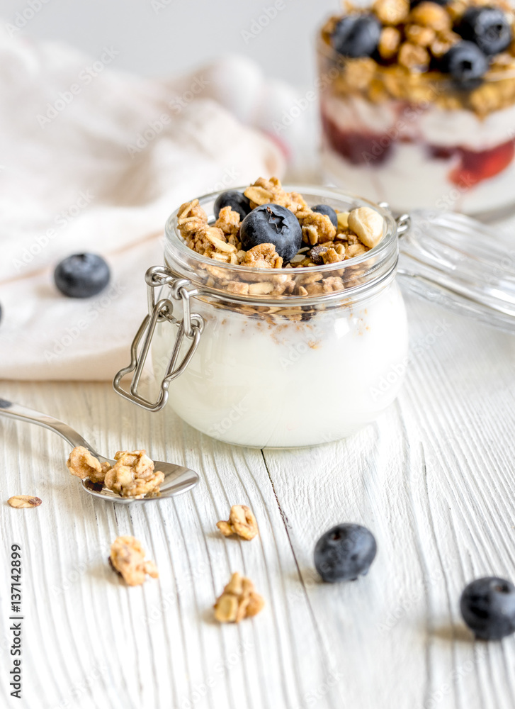 Homemade fitness granola with yoghurt and berries on white kitchen background