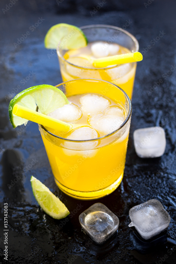 Alcohol cocktails with lime and ice on dark background