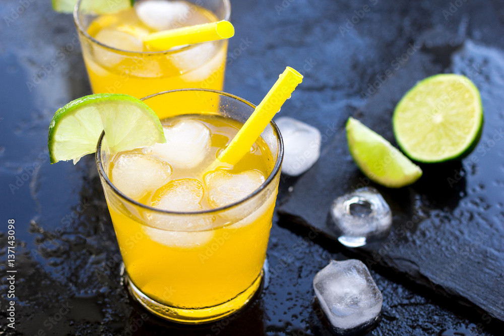 Alcohol cocktails with lime and ice on dark background