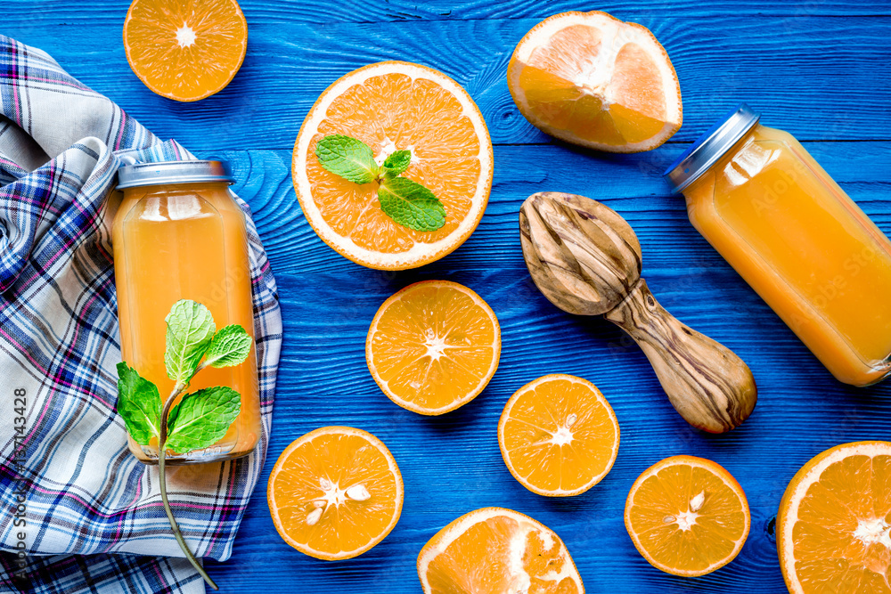 Homemade juice bottles with orange and mint on table top view