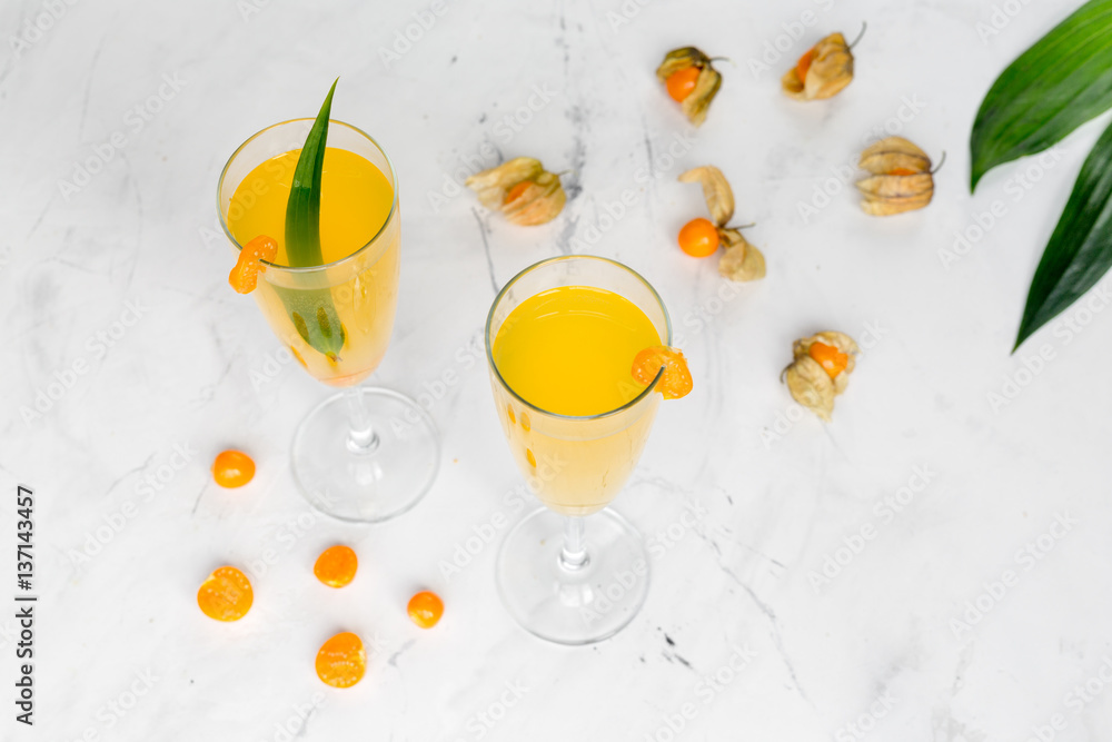 cocktail with physalis in glass on stone background