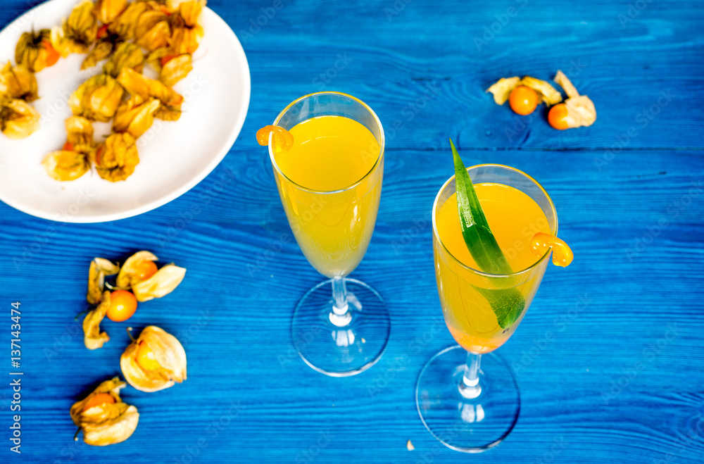 cocktail with physalis in glass on wooden background