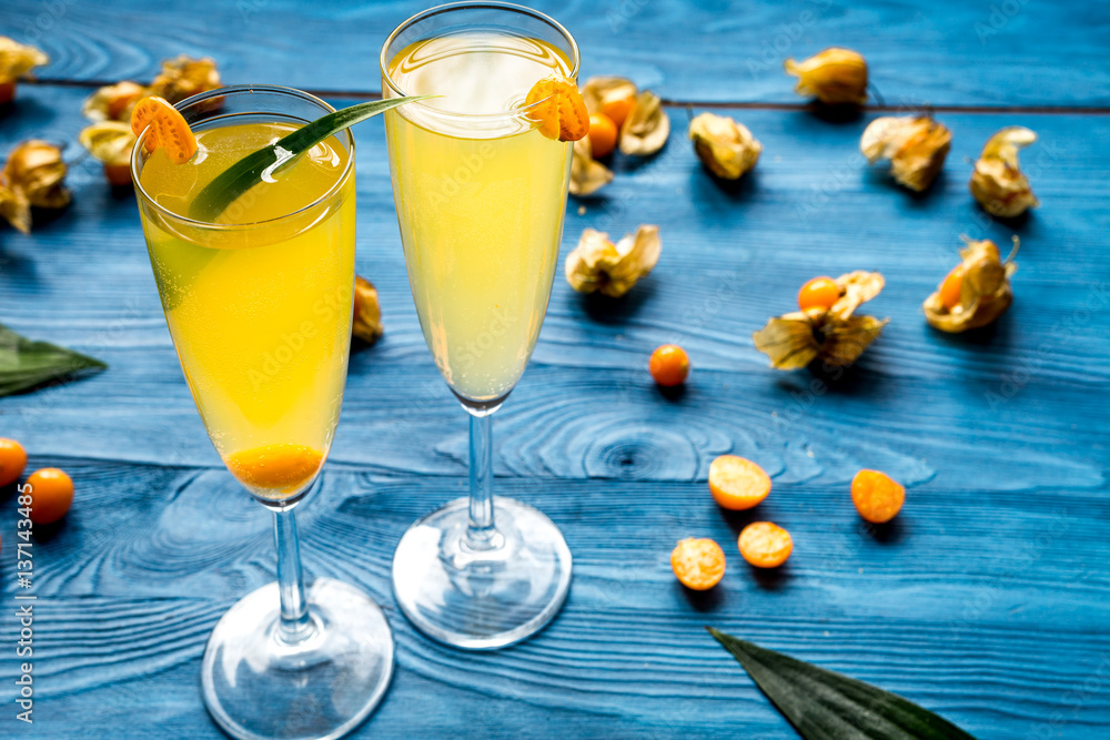 cocktail with physalis in glass on wooden background