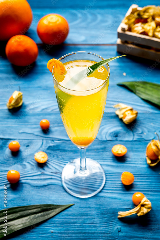 cocktail with physalis in glass on wooden background