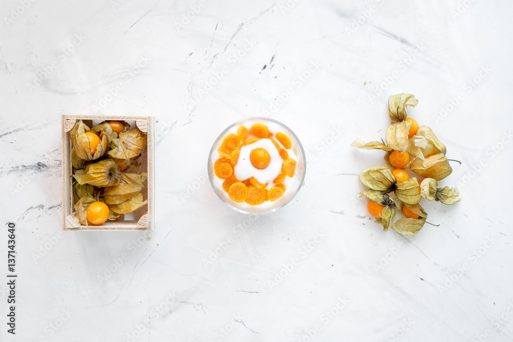 yogurt with physalis on stone background top view