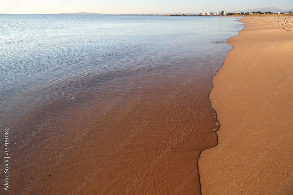 calm transparent sea and the sandy beach