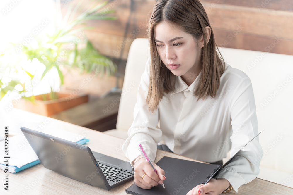 Modern business woman or successful working on laptop computer and notebook at coffee shop interior,