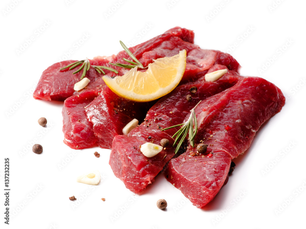 Pieces of meat with garlic and rosemary isolated on white background. Raw beef.