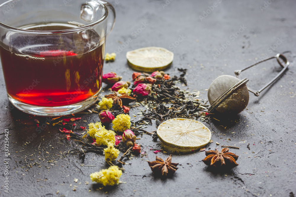 Teacup and herbs on grey background