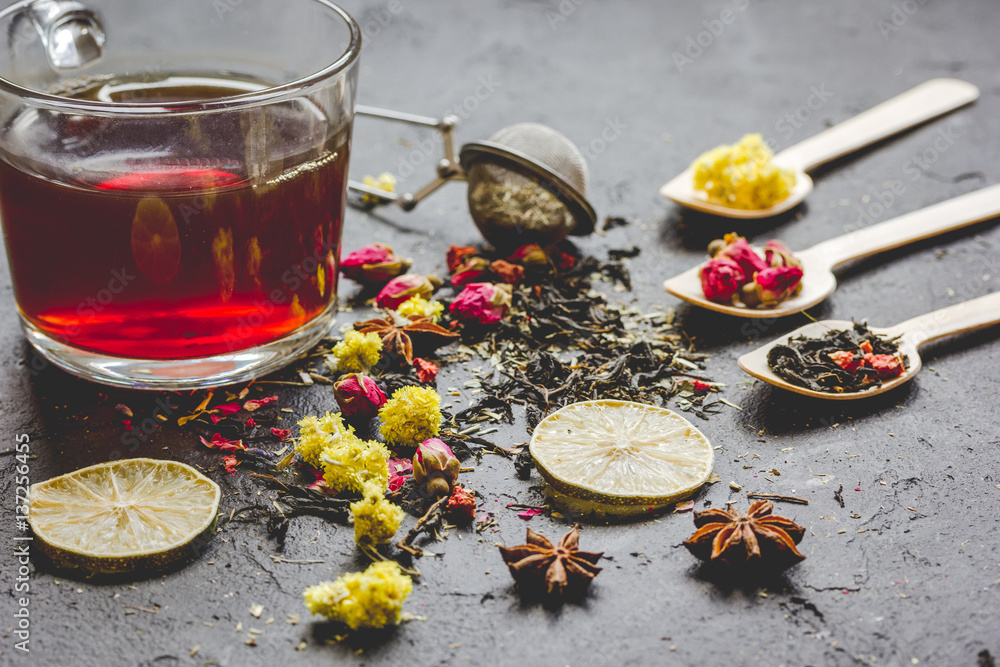 Teacup and herbs on grey background