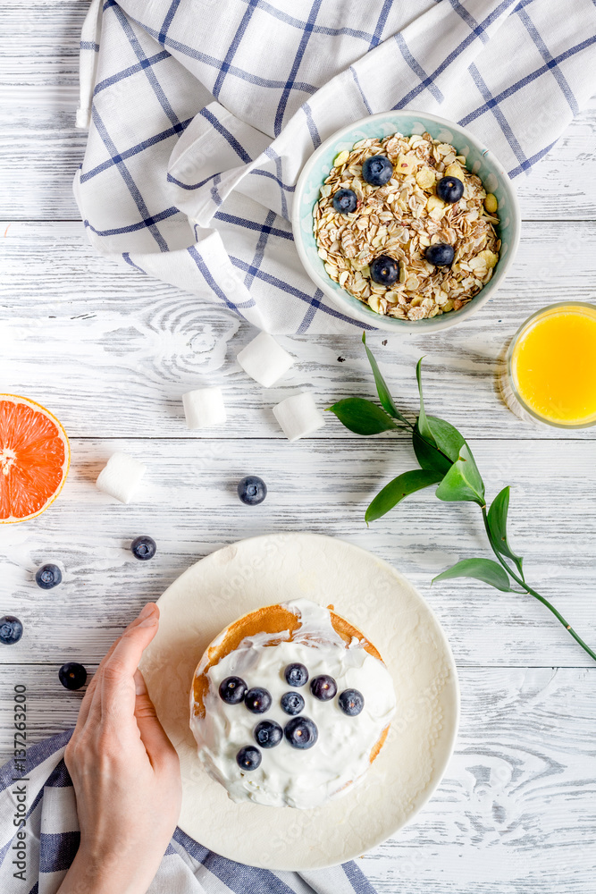 Breakfast concept with flowers on wooden background top view