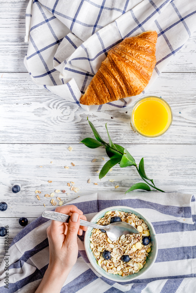 Breakfast concept with flowers on wooden background top view