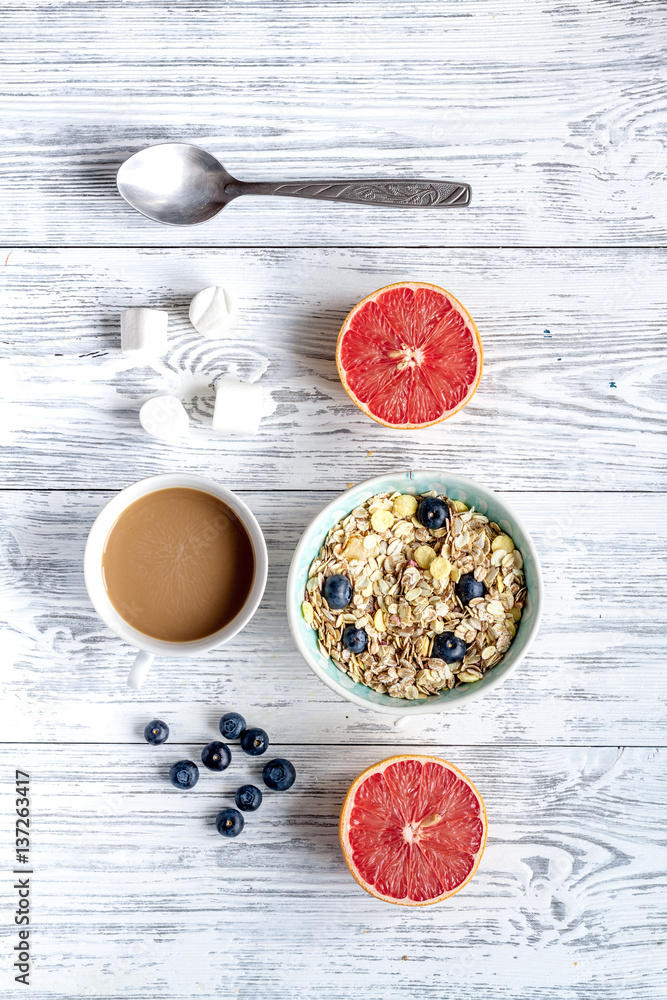 Breakfast concept with flowers on wooden background top view