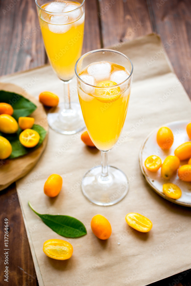 cocktail with kumquat on wooden background