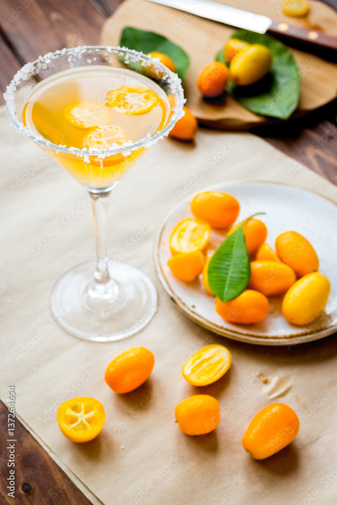 cocktail with kumquat on wooden background