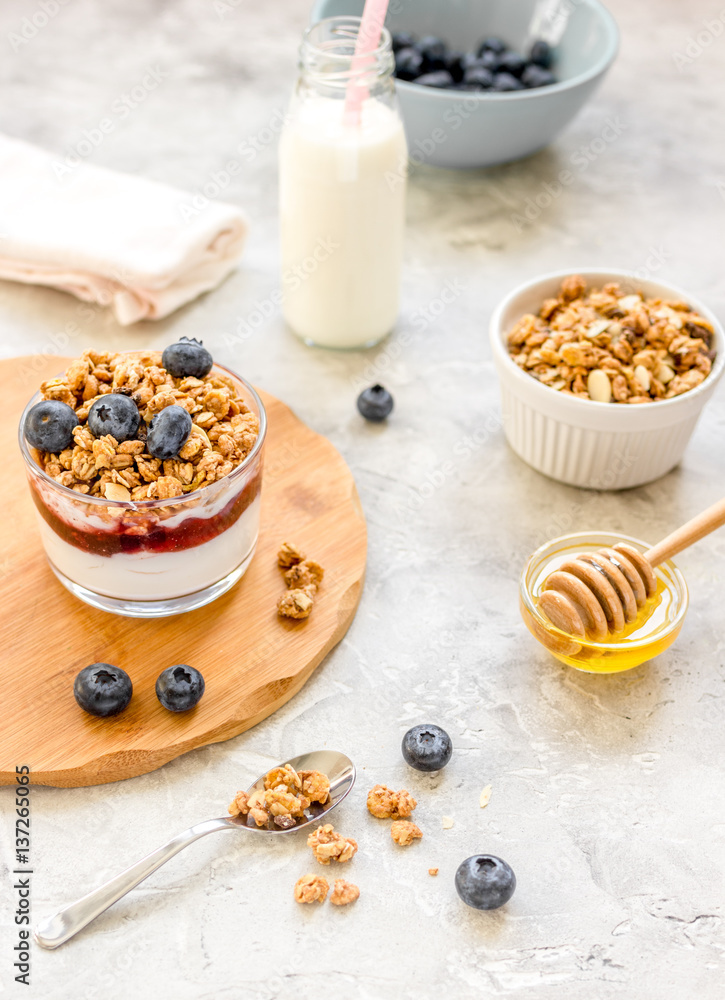 Morning granola with yogurt, honey and berries on white table