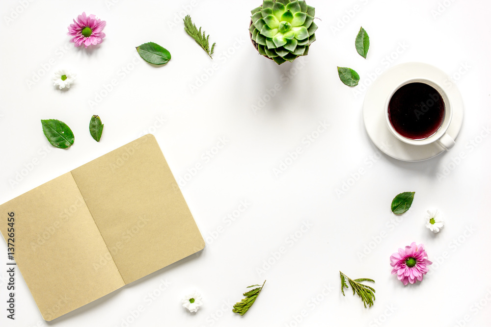 Coffee cup with flower petals and notebook top view mock-up