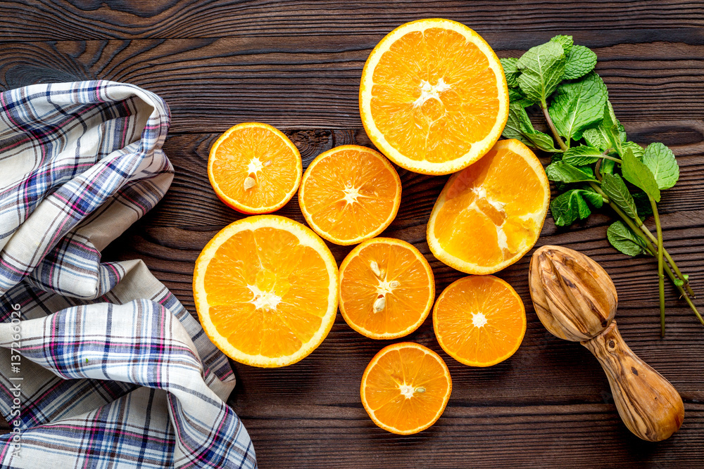 orange juice with mint squeezing on wooden kitchen background top view