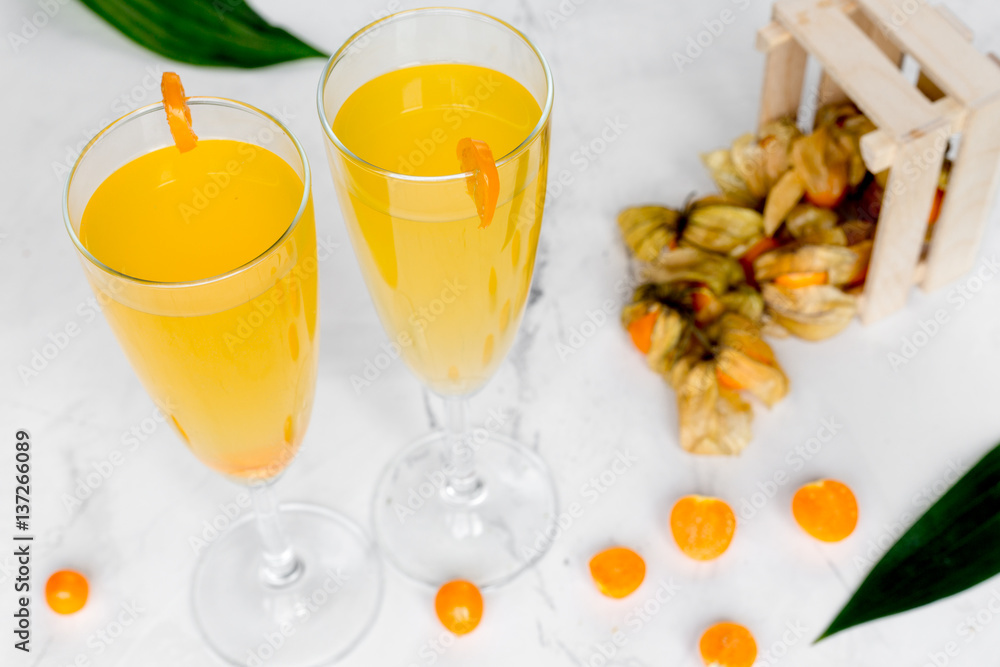 cocktail with physalis in glass on stone background