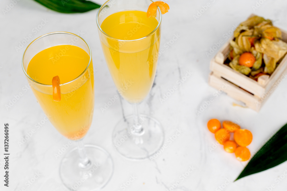 cocktail with physalis in glass on stone background