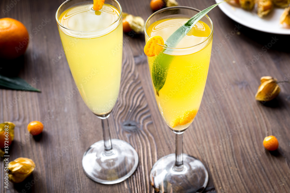 cocktail with physalis in glass on wooden background