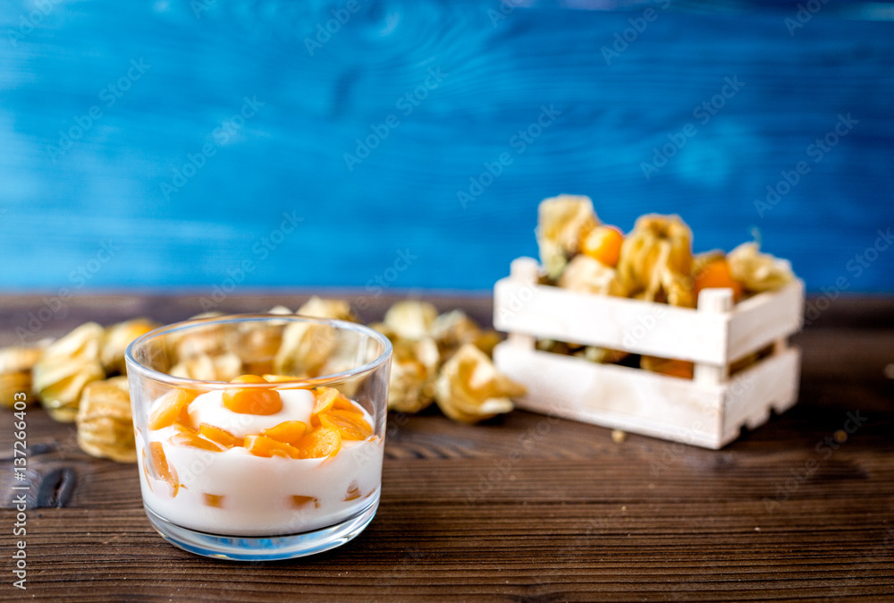 yogurt with physalis on wooden background