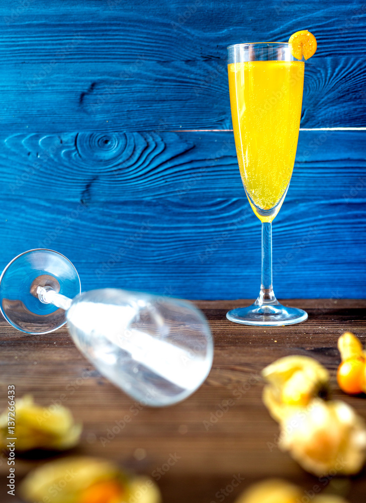 cocktail with physalis in glass on wooden background