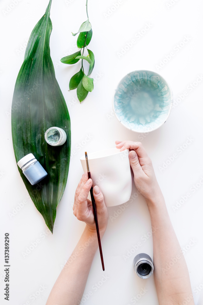 painted ceramic cup on white background top view