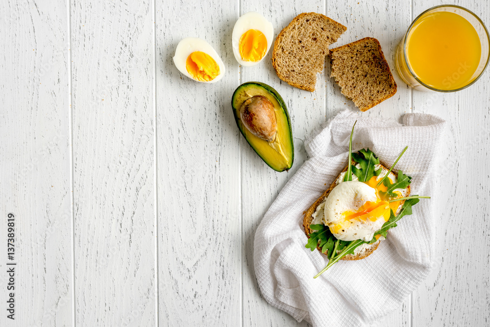 sandwich with poached eggs on wooden background top view mockup