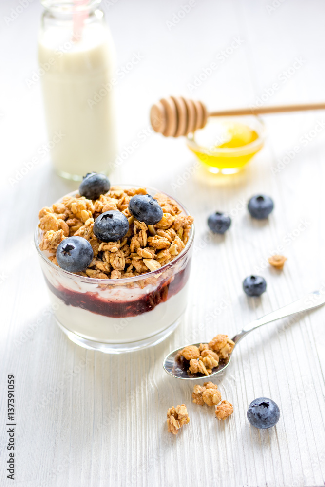 Fitness breakfast with muesli, honey and milk on white table