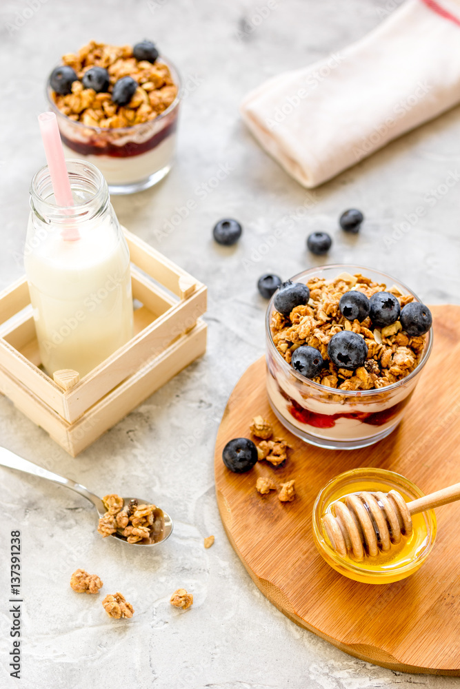 Morning granola with yogurt, honey and berries on white table