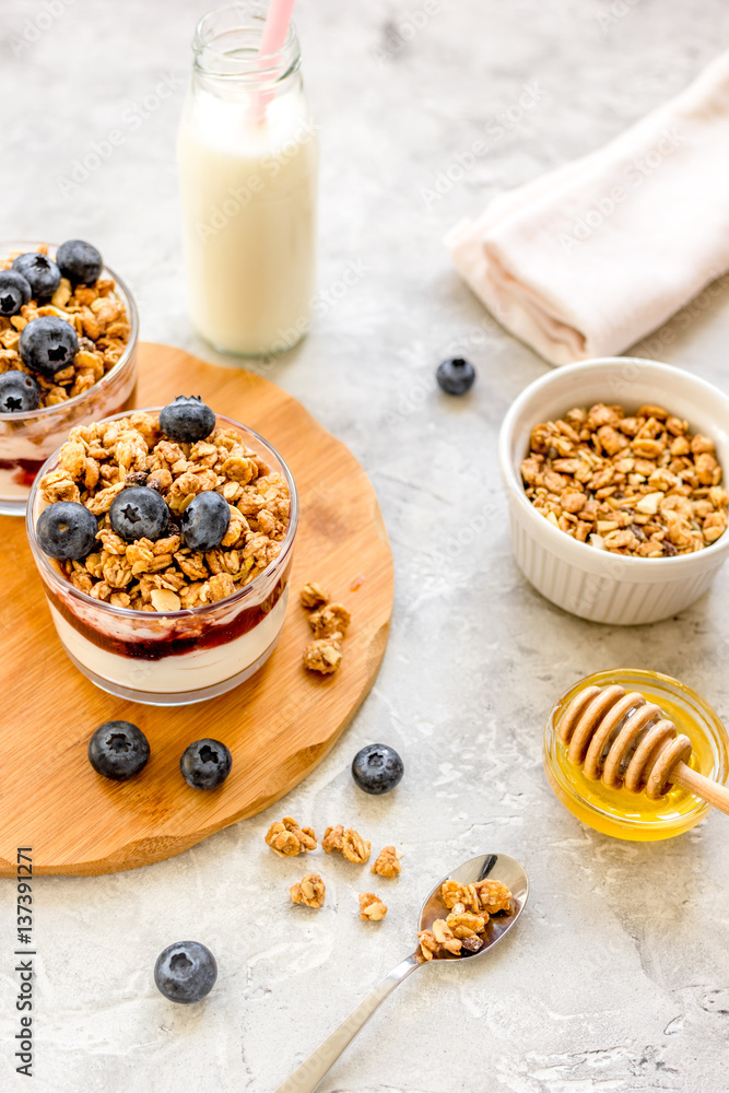 Morning granola with yogurt, honey and berries on white table