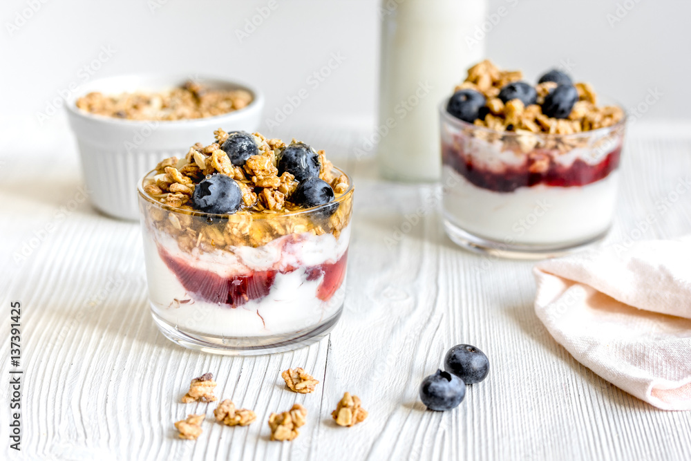 Morning granola with yogurt and berries on white kitchen background