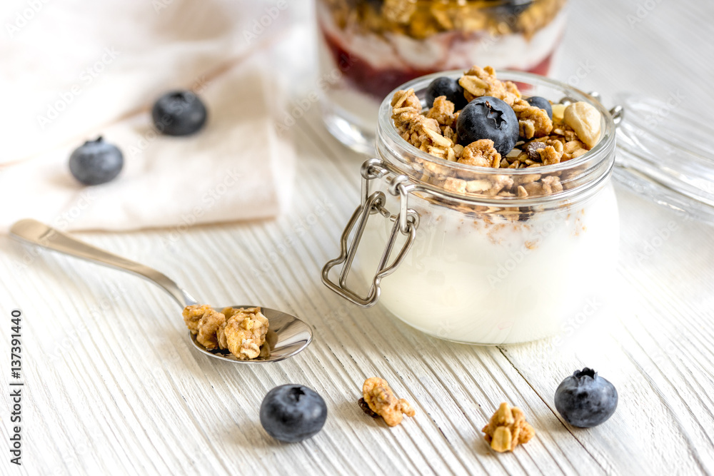 Homemade fitness granola with yoghurt and berries on white kitchen background