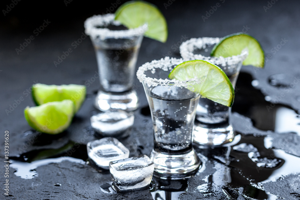 Alcohol party with tequila, ice and salt on black background