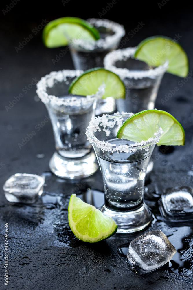 Alcohol party with tequila, ice and salt on black background