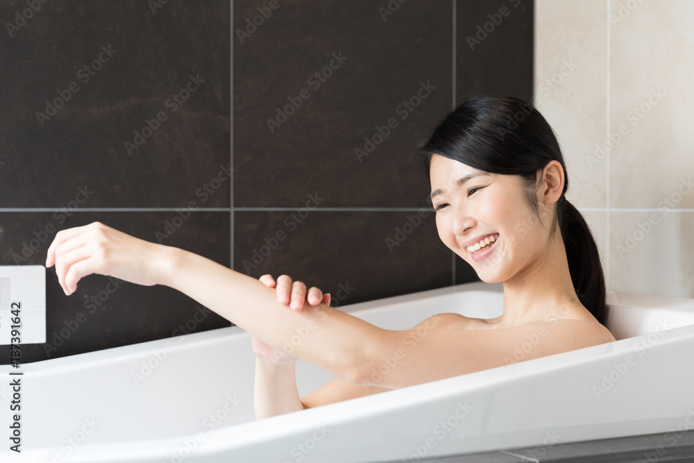 attractive asian woman relaxing in bathtub