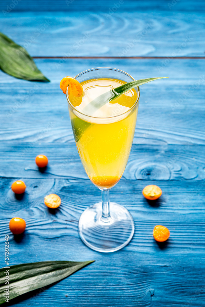 cocktail with physalis in glass on wooden background