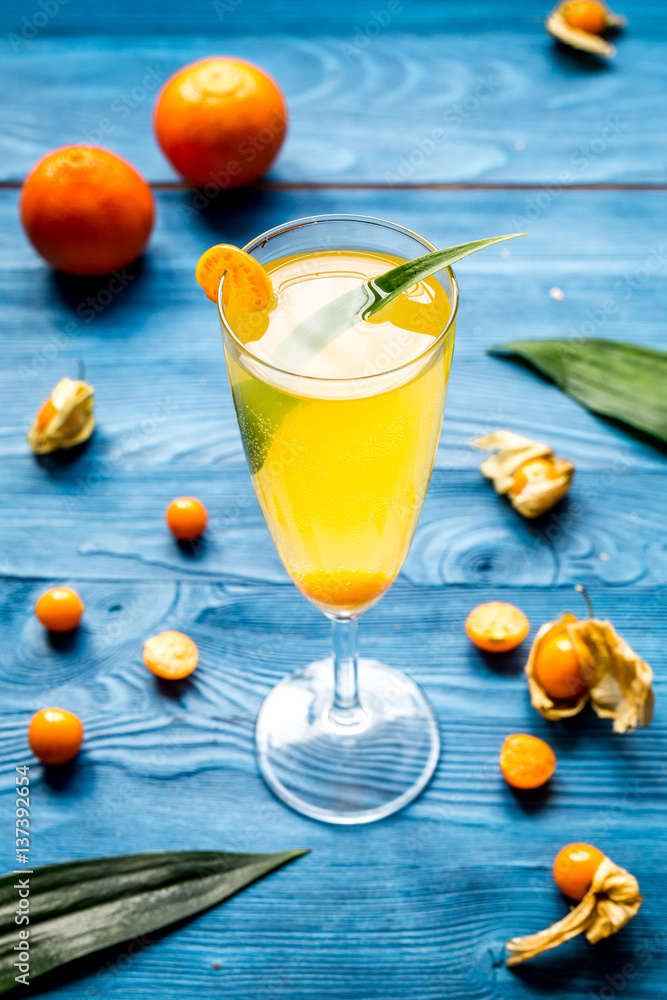 cocktail with physalis in glass on wooden background