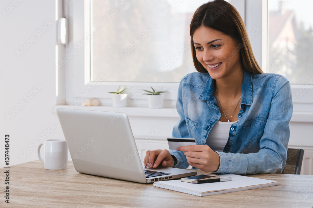 Portrait of a Girl holding credit card and using laptop. Online shopping