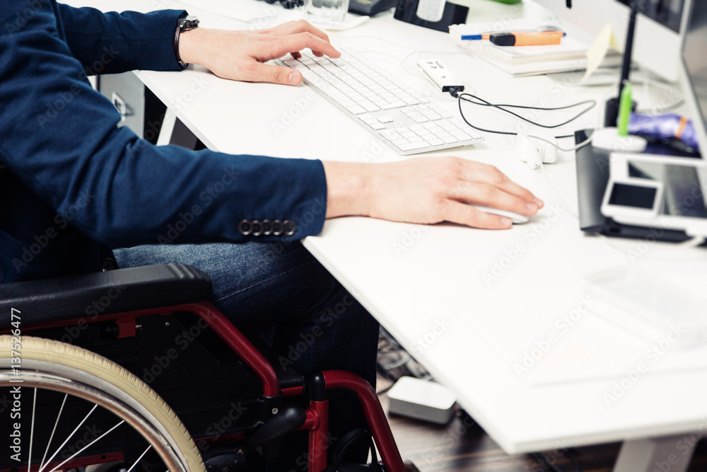 Man Sitting In Wheelchair Working In Modern Office