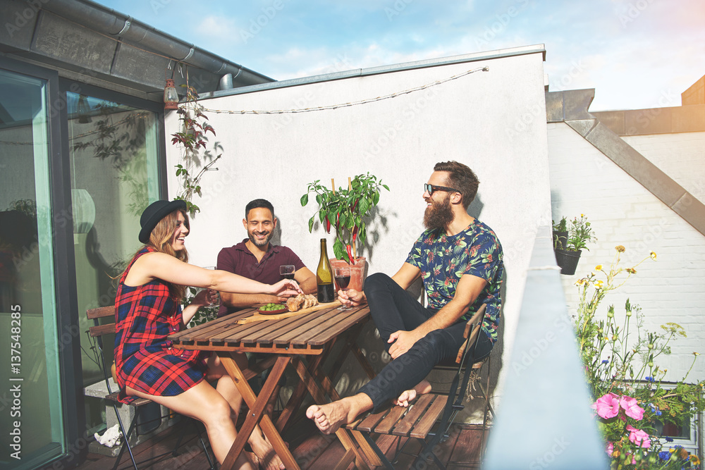 Bearded man with couple drinking wine on roof