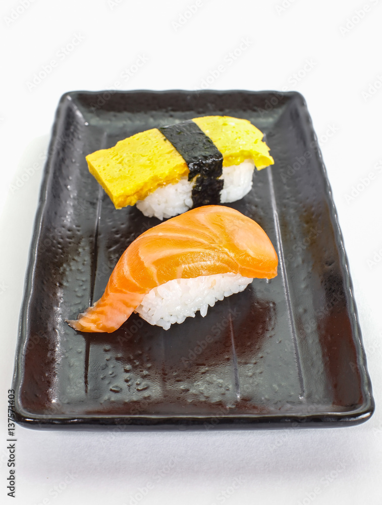 Japanese sushi raw seafood, vegetables and serving of cooked vinegared rice on white table backgroun