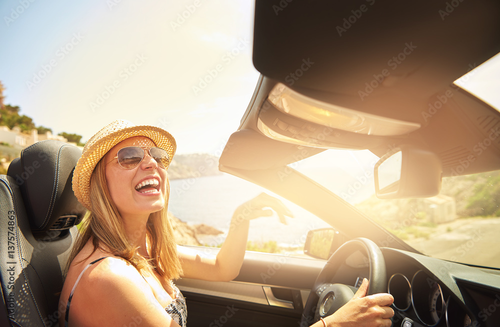 Woman laughing while driving fancy car