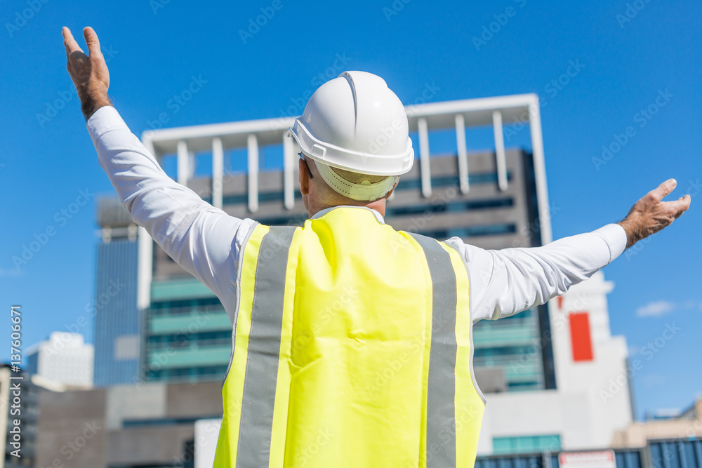 Senior foreman in glasses doing his job at building area on sunny day